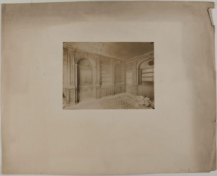 Comptoir et étagères d’une pharmacie parisienne, produits en arrière-plan, vue d’ensemble horizontale.