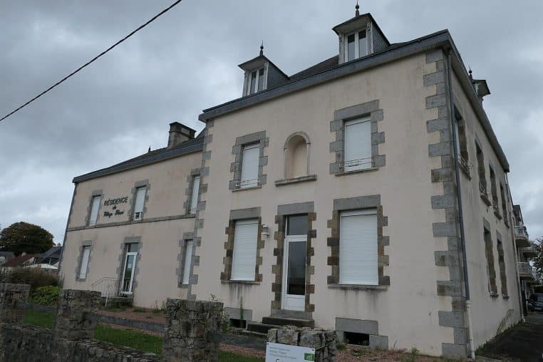 Façade d’un établissement d’hébergement pour personnes âgées dépendantes à Juvigné, vue large de l’entrée principale et des abords végétalisés.