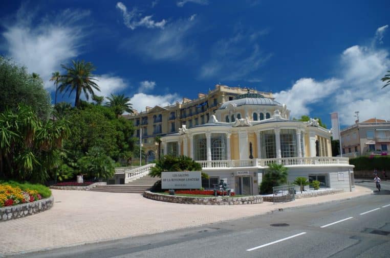 Vue large de La Rotonde à Beaulieu-sur-Mer, bâtiment élégant entouré de palmiers et d’hôtels de luxe sous un ciel bleu