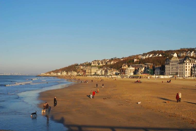 La grande plage de Trouville avec promeneurs et cabines, large horizon sur la Manche et façades du front de mer en lumière d’hiver.