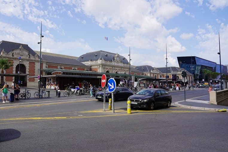 Façade voyageurs de la gare de Nice-Ville, avec l’immeuble Iconic à droite, ciel clair et perspective sur l’esplanade.