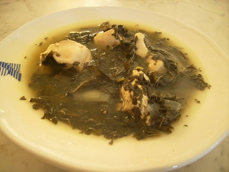 Assiette creuse de mulukhiyah libanaise avec morceaux de poulet, bouillon léger et feuilles finement hachées.