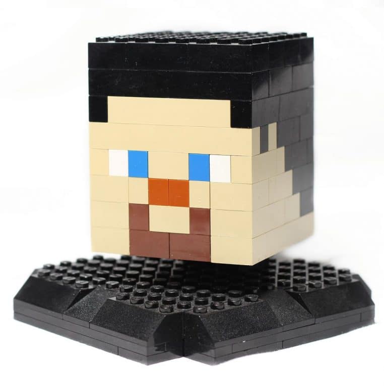 Grosse tête de Creeper LEGO Minecraft photographiée en plan large, fond neutre, composition horizontale pour illustrer un jouet.