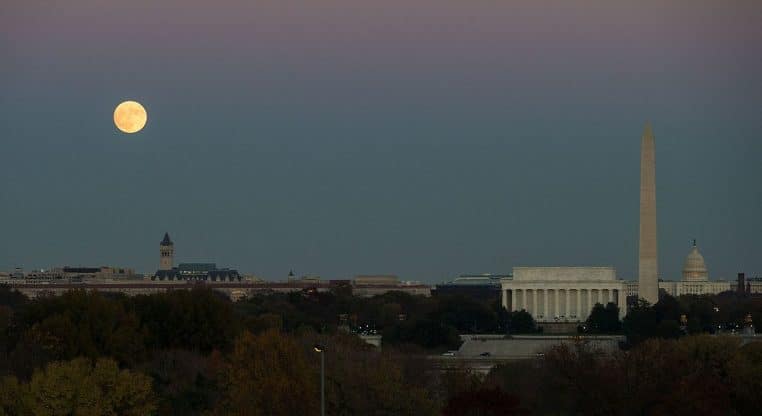 Lune se levant sur Washington DC avec le Lincoln Memorial et le Washington Monument sous un ciel crépusculaire.