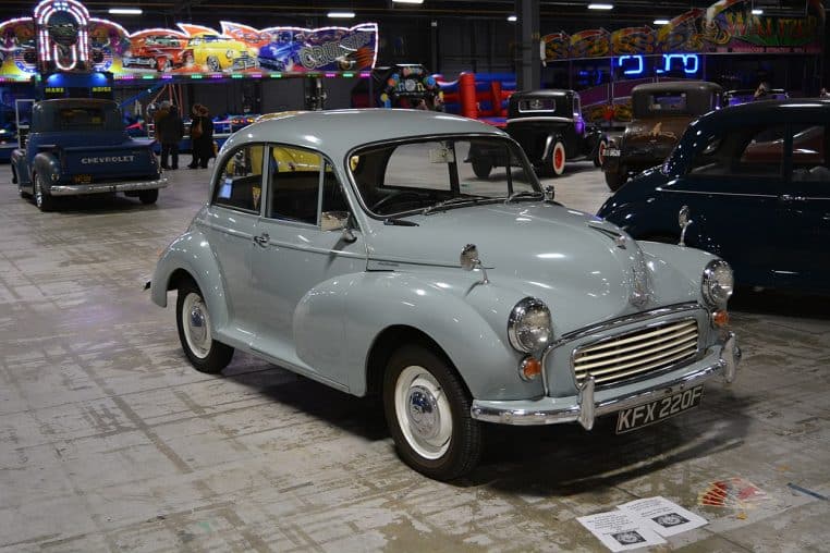 Morris Minor 1000 bleu pastel stationnée en intérieur, photographiée de profil, illustrant une citadine anglaise de collection restaurée.