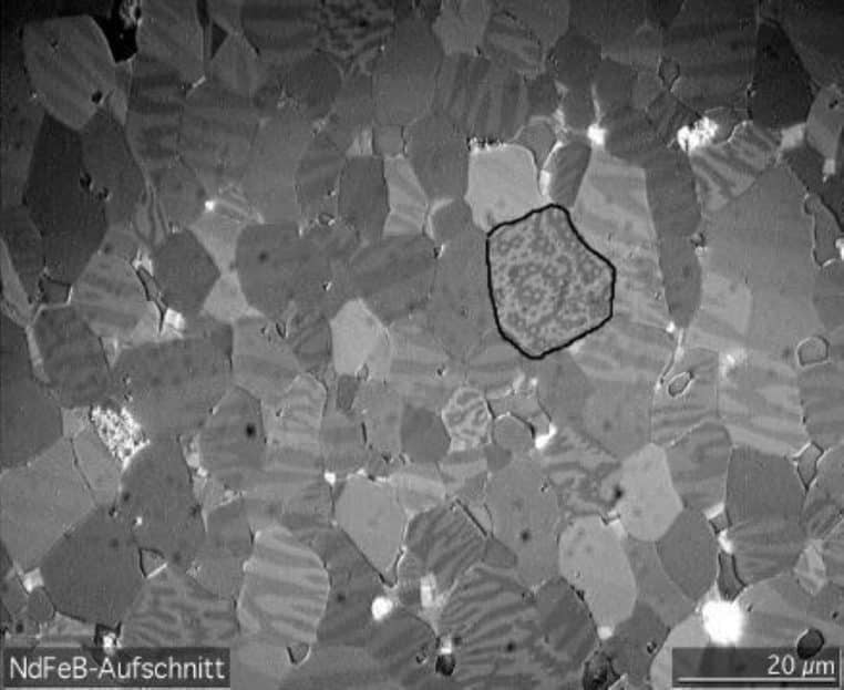 Photomicrographie d’un matériau magnétique à base de néodyme montrant la structure en domaines, illustrant la façon dont les métaux de terres rares forment des cristaux au niveau microscopique.