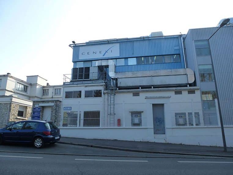 Vue extérieure d’une usine pharmaceutique française avec bâtiments industriels et parkings, illustrant les sites de production de médicaments sur le territoire.