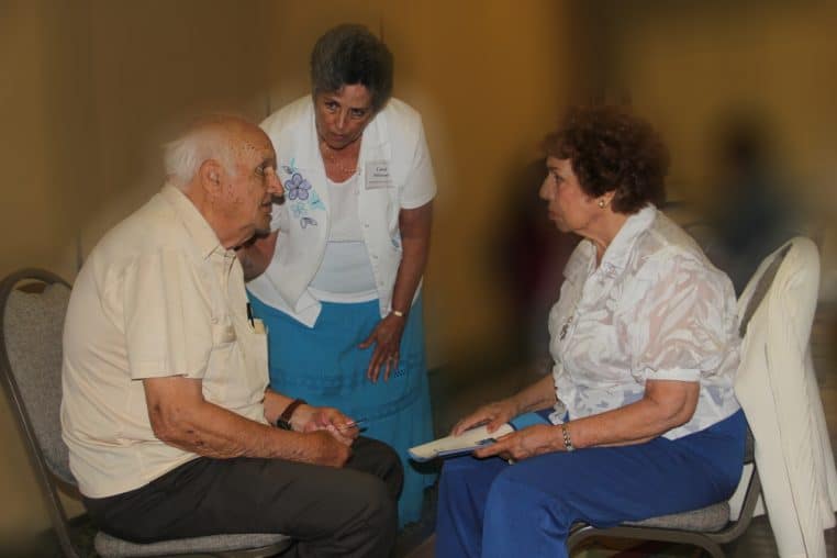 Un couple de seniors en discussion avec une animatrice pendant un atelier, symbolisant la préparation de la retraite et le dialogue autour des droits à pension.