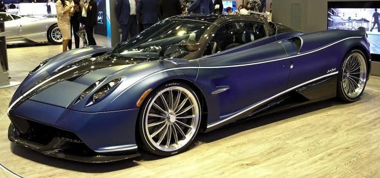 Pagani Huayra Roadster exposée en salon automobile, vue de profil trois quarts avec éclairage de stand et visiteurs autour du véhicule