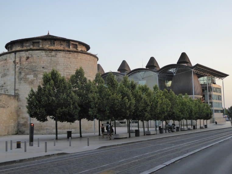 Large plan des salles d’audience en bois du palais de justice de Bordeaux, sous la verrière, vue estivale et ciel dégagé.