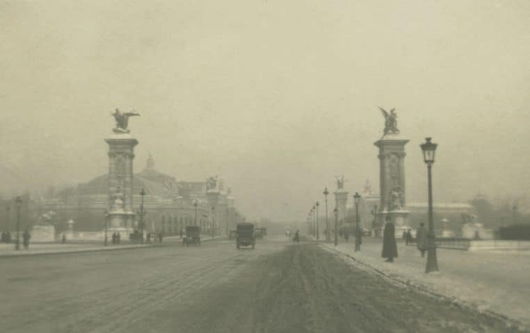 Scène hivernale sur le pont Alexandre III à Paris en janvier 1919, chaussée enneigée et silhouettes traversant par grand froid sous un ciel pâle.