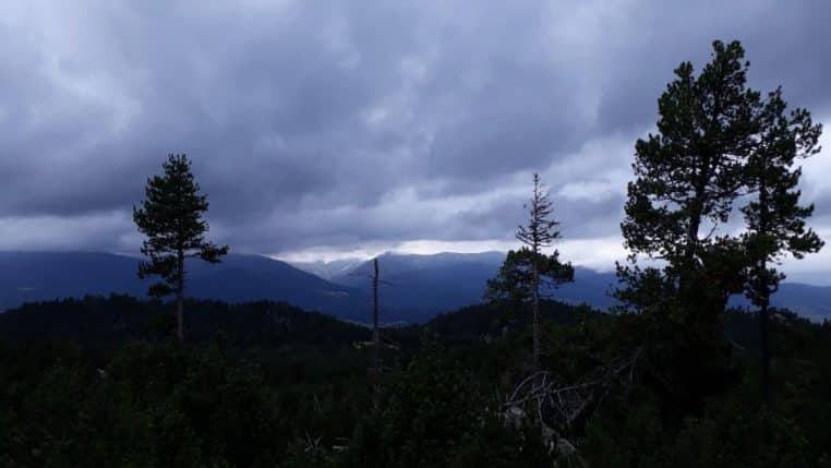Paysage du Capcir sous un ciel instable, larges prairies et reliefs des Pyrénées-Orientales avec traces de neige sur les hauteurs.