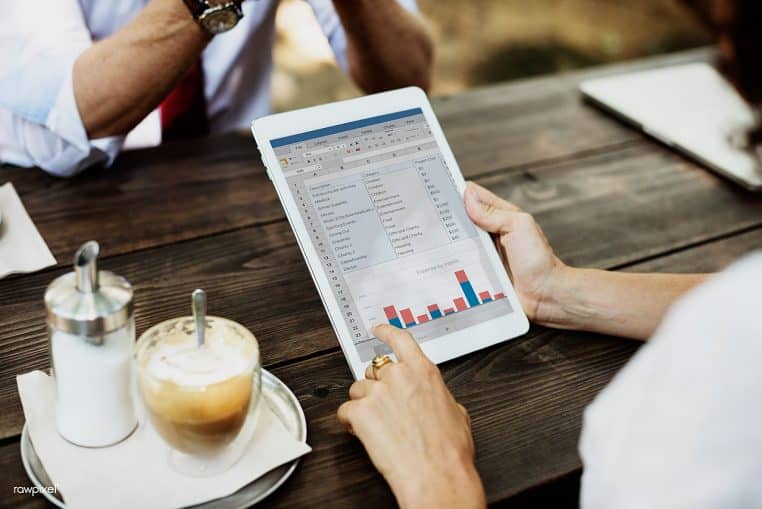 Groupe d’amis discutant autour d’une table dans un coffee shop, regards attentifs et ambiance chaleureuse, composition horizontale lumineuse.