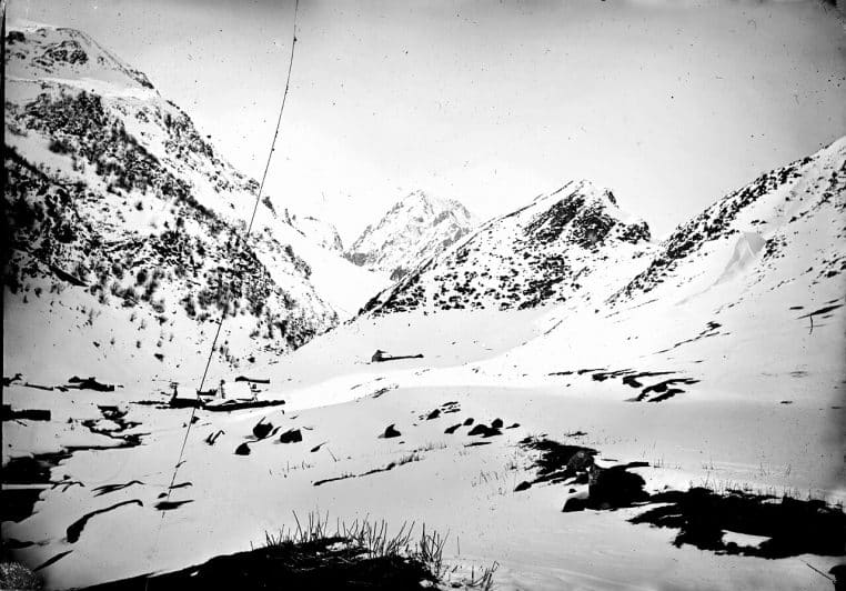 Photographie ancienne en noir et blanc du Pic du Midi en hiver, vallon enneigé entouré de pentes chargées de neige et cimes au fond.