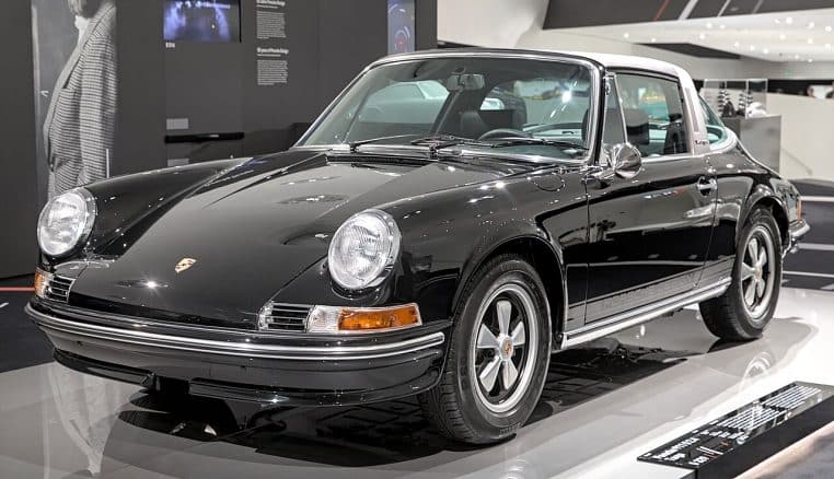 Porsche 911 S 2.4 Targa exposée en intérieur, entièrement restaurée, mise en valeur sur un podium avec un éclairage de musée automobile.