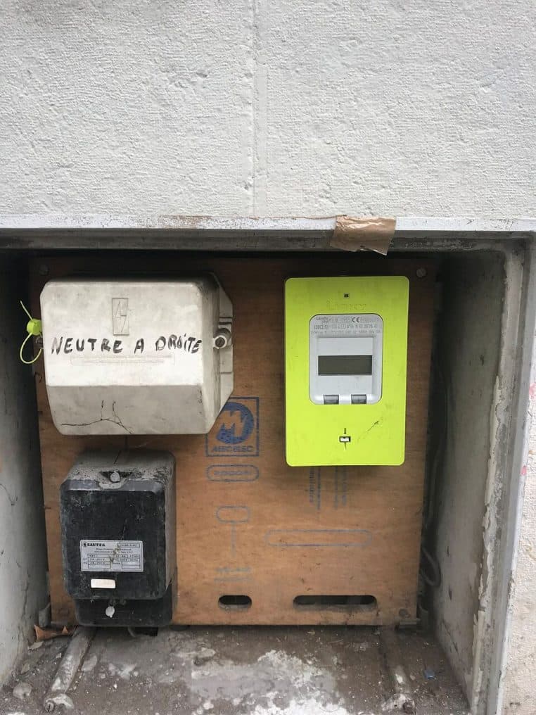 Compteur Linky monté en façade dans une rue lyonnaise, boîtier repérable dans un coffret extérieur.
