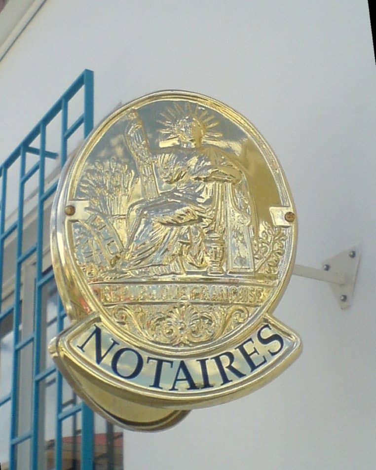 Panonceau « Notaires » fixé sur la façade d’un office notarial, typographie noire sur fond clair, vue horizontale nette.