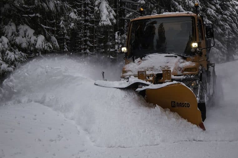 Chasse-neige au travail sur une route du Harz, projection de neige et talus chargés après les averses