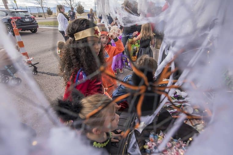 Coffre de voiture décoré pour Halloween avec citrouilles et toiles d’araignée lors d’un évènement, vue horizontale