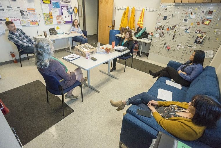 Réunion en petit comité dans un open space, participants concentrés, échange posé autour d’un point précis à clarifier.