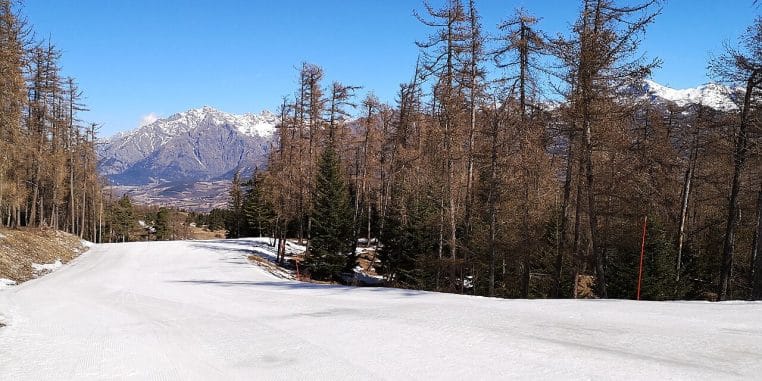 Pistes de la station de Laye dans les Hautes-Alpes avec télésièges, neige fraîche et crêtes montagneuses sous un ciel dégagé.