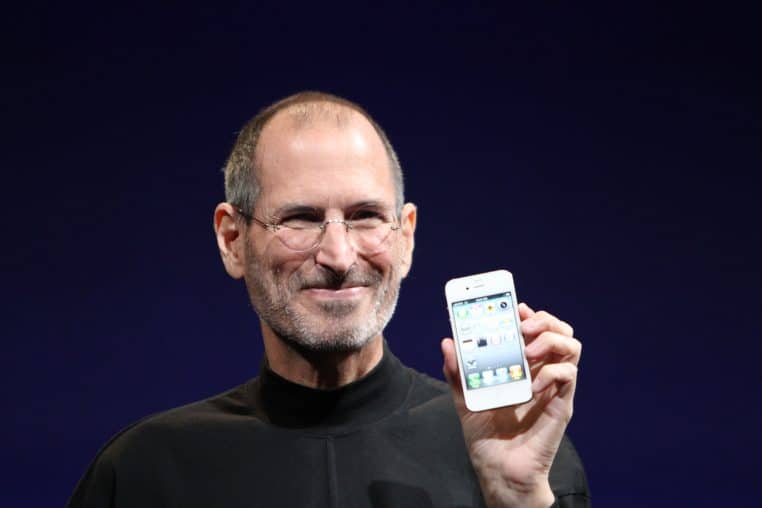 Portrait de Steve Jobs en gros plan lors d’une conférence en 2010, regard concentré vers le public, sur un fond neutre flou.