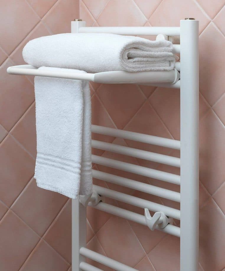 Sèche-serviettes blanc dans une salle de bain ; montée ponctuelle à 22 °C pour éviter le choc thermique après la douche.