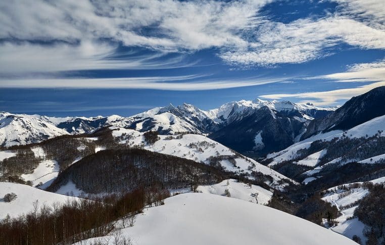Large vue hivernale de la vallée d’Aspe, versants enneigés et ciel lumineux au-dessus d’Accous.