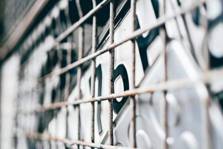 Gros plan sur des pièces d’aluminium stockées derrière une grille, évoquant la valorisation industrielle de ce métal recyclé.