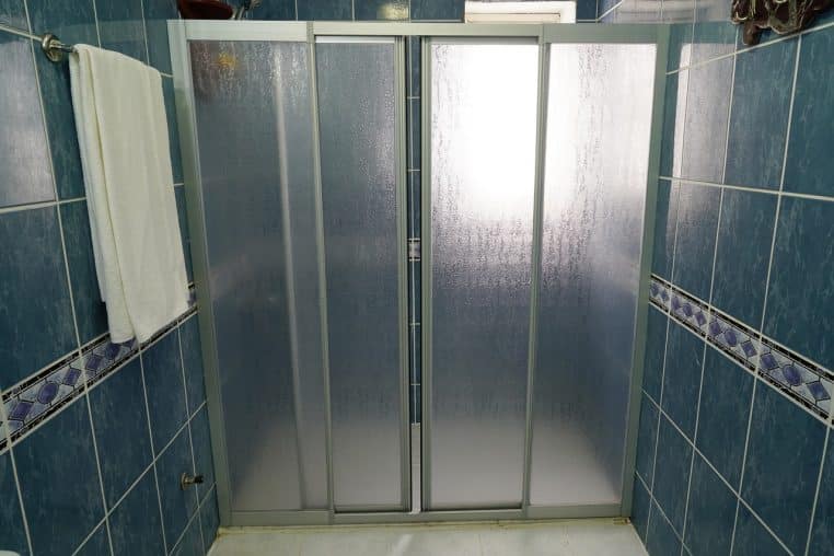 Gros plan sur une cabine de douche moderne propre, prête à l’emploi pour une toilette rapide et douce.