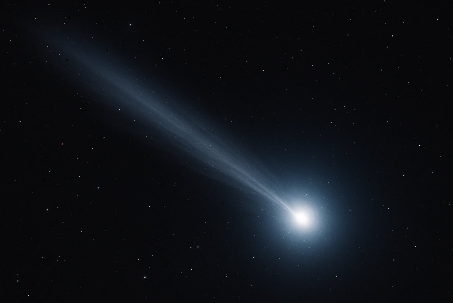 Illustration réaliste de la comète interstellaire 3I/ATLAS, noyau bleu-blanc éclatant et longue queue lumineuse se détachant sur un ciel dense d’étoiles.