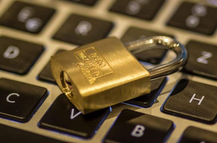 Cadenas doré posé sur un clavier d’ordinateur, illustrant la protection des données et la cybersécurité dans la défense.