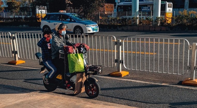 Père et enfant à vélo électrique en ville, symbolisant les trajets du quotidien facilités par l’assistance électrique.