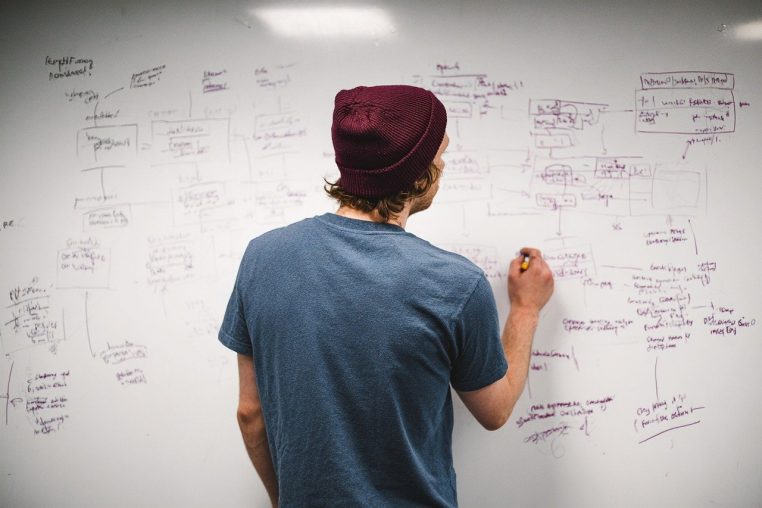 Équipe d’ingénieurs réunis autour d’un bureau avec plans et ordinateurs, illustrant les besoins en profils techniques et numériques en Suisse