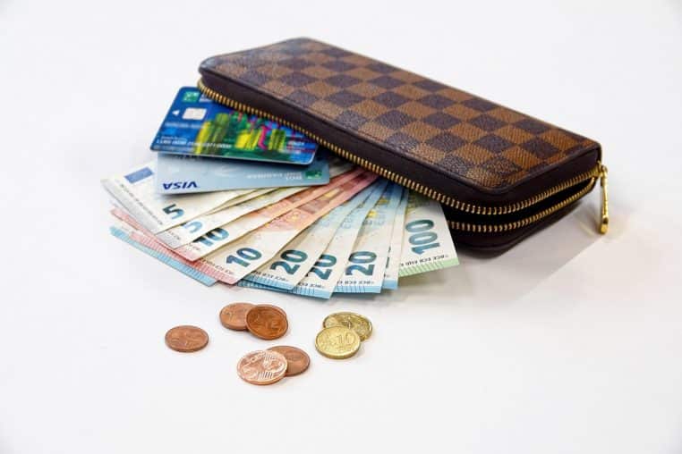 Pièces et billets en euro disposés sur une table, représentant plusieurs moyens de paiement en espèces.