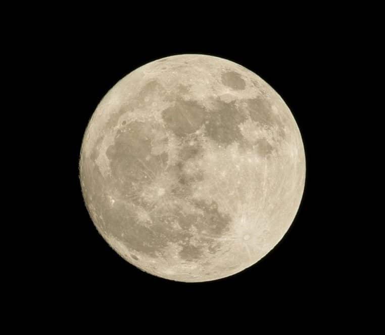 Gros plan sur le disque de la pleine lune sur fond de ciel noir, montrant cratères et mers lunaires en détail