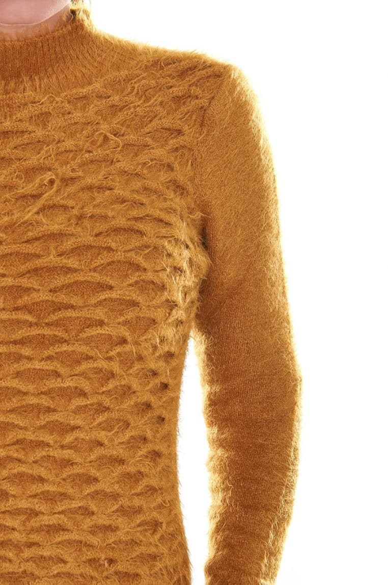 Gros plan sur un pull en mohair moutarde à col montant, mettant en avant la texture du tricot sur le buste et la manche.