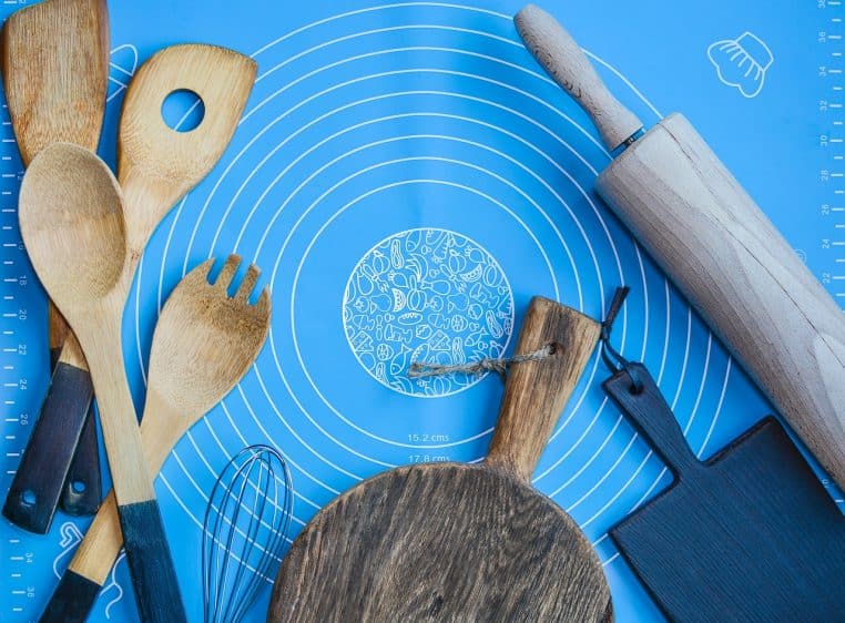 Ensemble d’ustensiles et d’appareils de cuisine en métal rangés sur un plan de travail, évoquant les robots et petits électroménagers du quotidien.