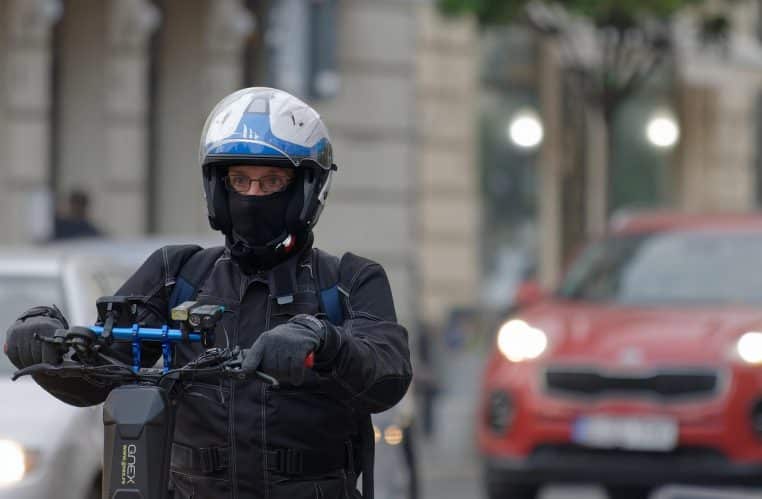 Homme circulant en trottinette électrique dans une rue urbaine, illustrant la mobilité douce et les déplacements quotidiens en ville.