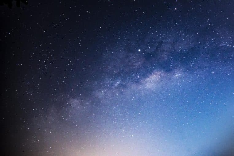 Voie lactée étirée dans le ciel nocturne au-dessus d’un paysage calme, illustrant la richesse en étoiles de notre propre galaxie