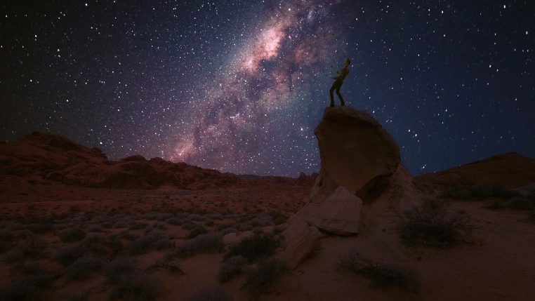 Voie lactée très lumineuse au-dessus d’un relief rocheux désertique, photographiée de nuit dans un site éloigné de toute agglomération.