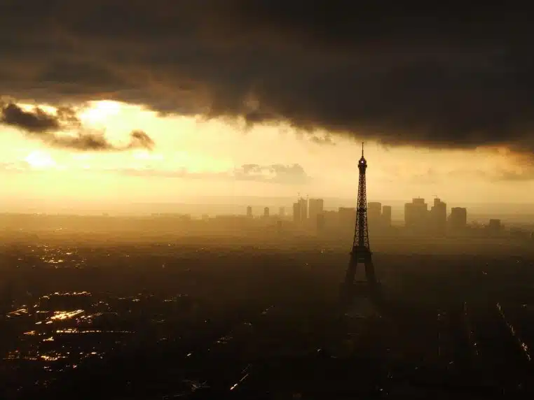 La tour Eiffel au crépuscule vue depuis les quais, baignée d’une lumière dorée qui souligne la silhouette de la capitale.