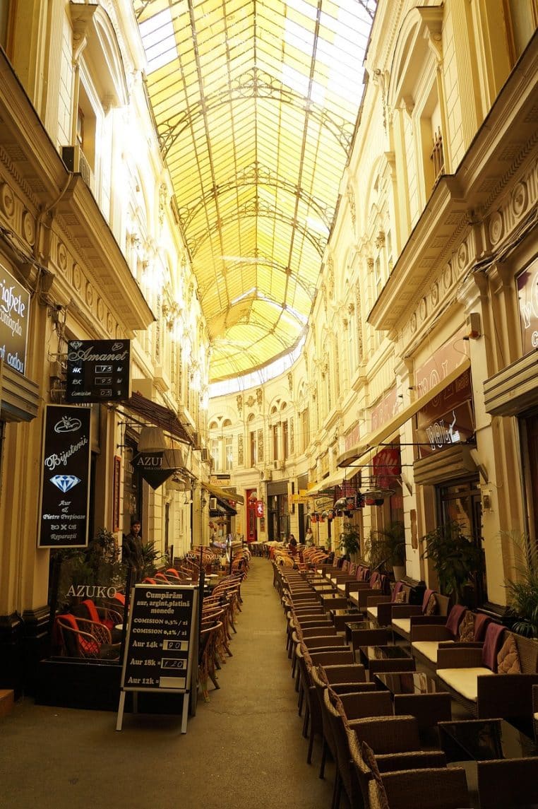 Rue pavée bordée d’immeubles anciens, avec passage piéton et trottoirs dégagés laissant une bonne vue aux automobilistes.