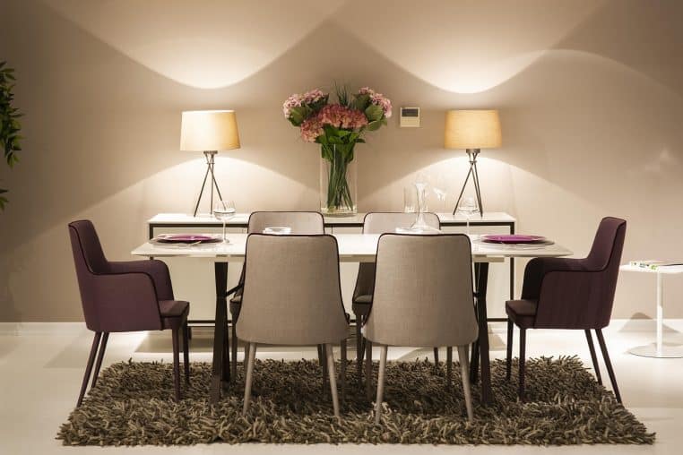 Table de réception parfaitement dressée avec couverts et verres alignés, ambiance feutrée, composition horizontale.