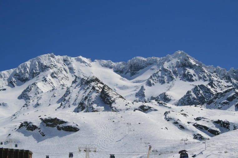 Panorama sur les montagnes enneigées dominant Val Thorens avec quelques chalets visibles au pied des pentes blanches