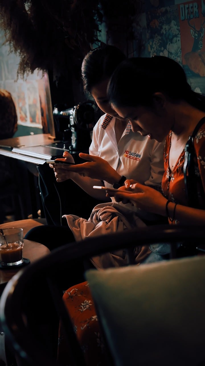 Colègues réunis autour d’une table de réunion, sourires et postures ouvertes suggérant un climat de confiance propice aux blagues.