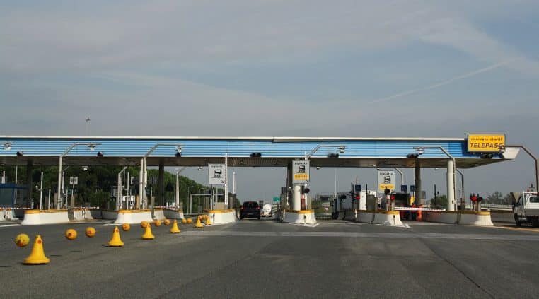 Barrière de péage sur l’autoroute A12 près de Livorno, en Italie, avec voies, cônes et signalisation.