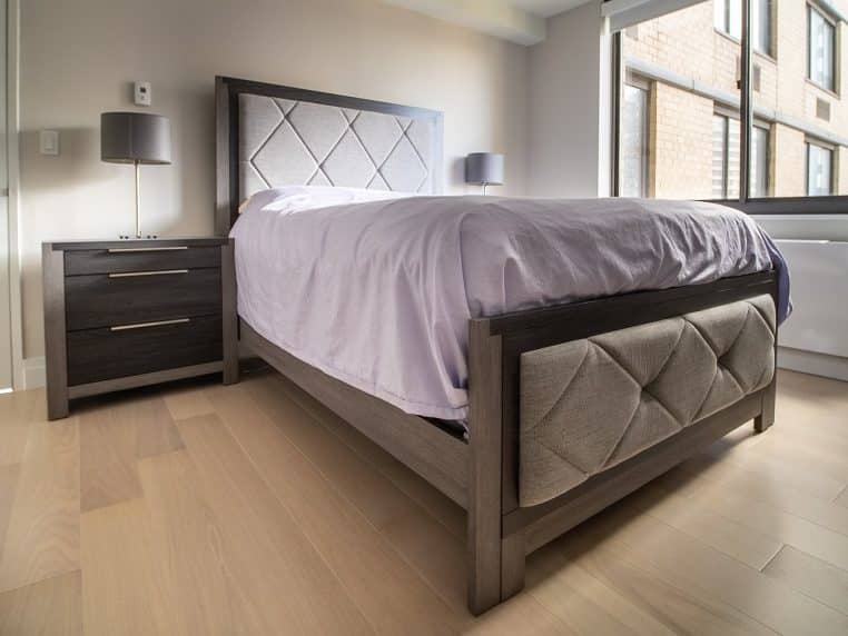 Ensemble complet de chambre à coucher avec grand lit, tête de lit et mobilier coordonné dans une ambiance chaleureuse.