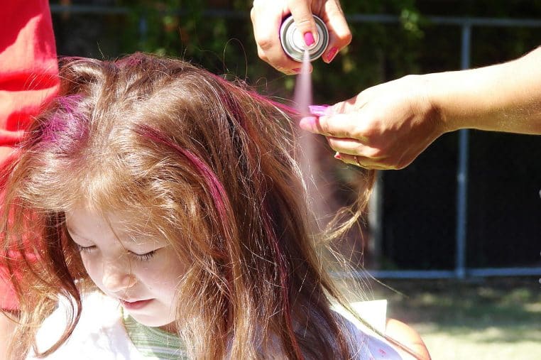 Coiffure réalisée au spray sur cheveux, photo en intérieur, illustration de produits utilisés en aérosol.