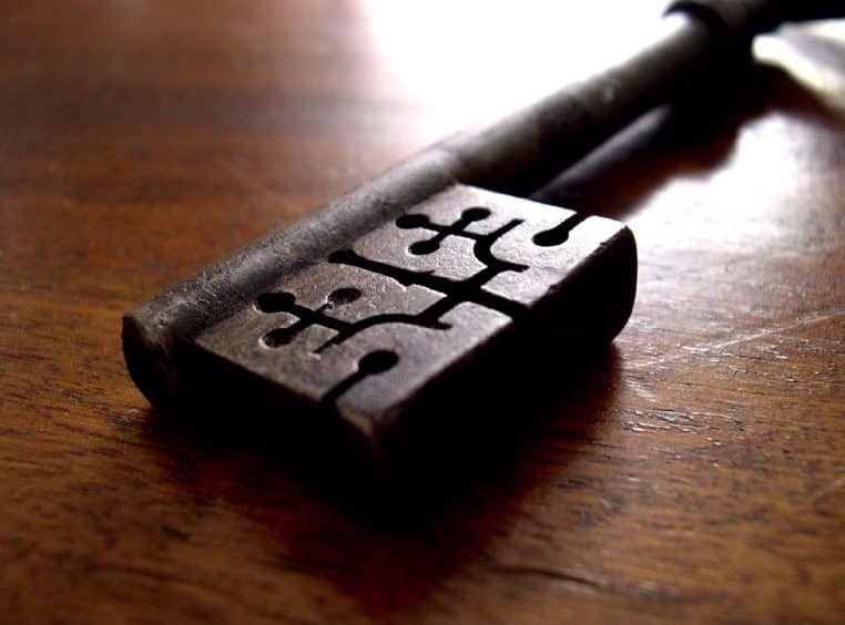 Vieille clé métallique posée sur une table en bois, évocation d’un foyer disputé et d’un héritage à protéger